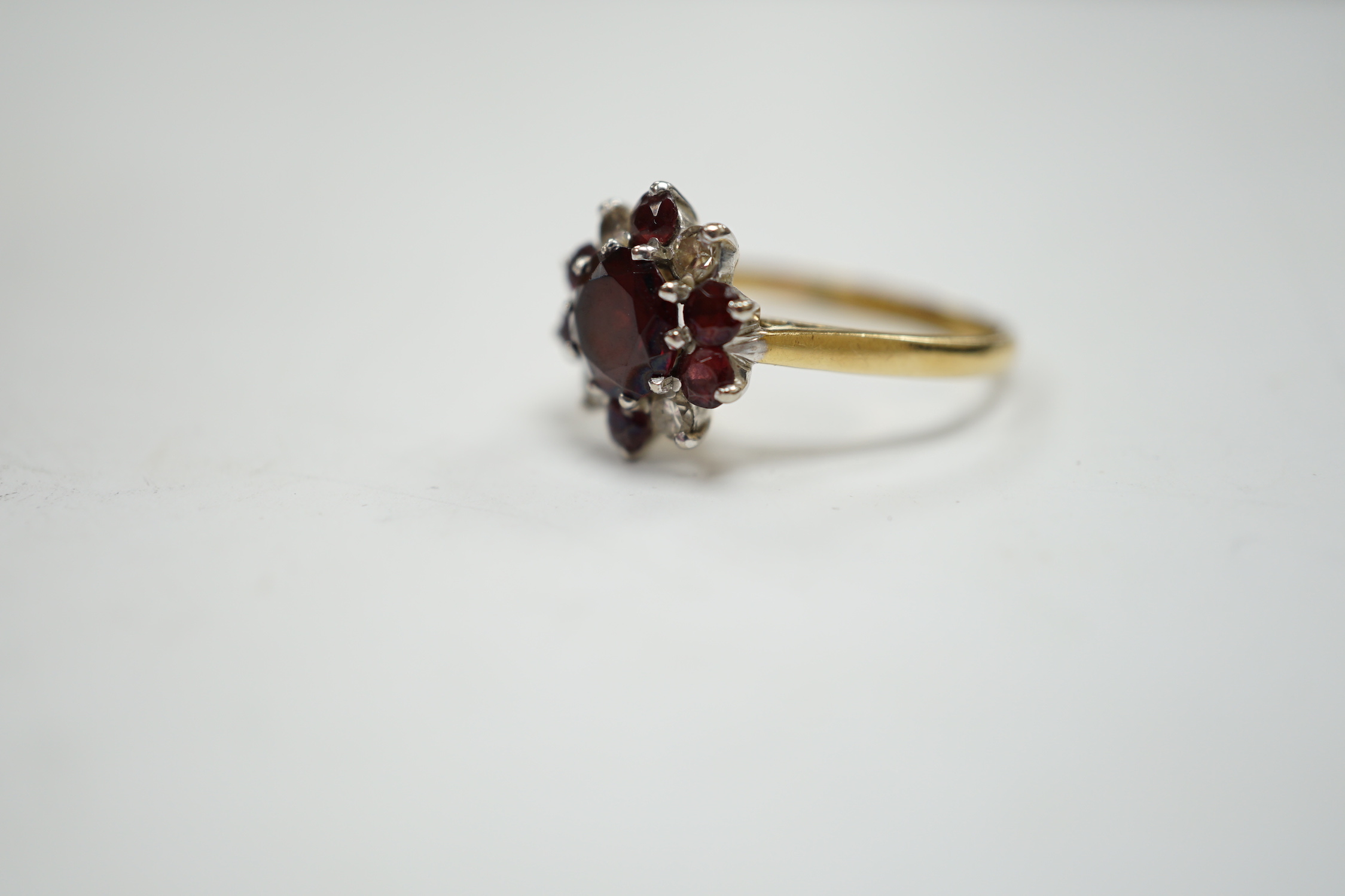 An 18ct red paste? and diamond cluster set flower head ring, size M, gross weight 3.2 grams.